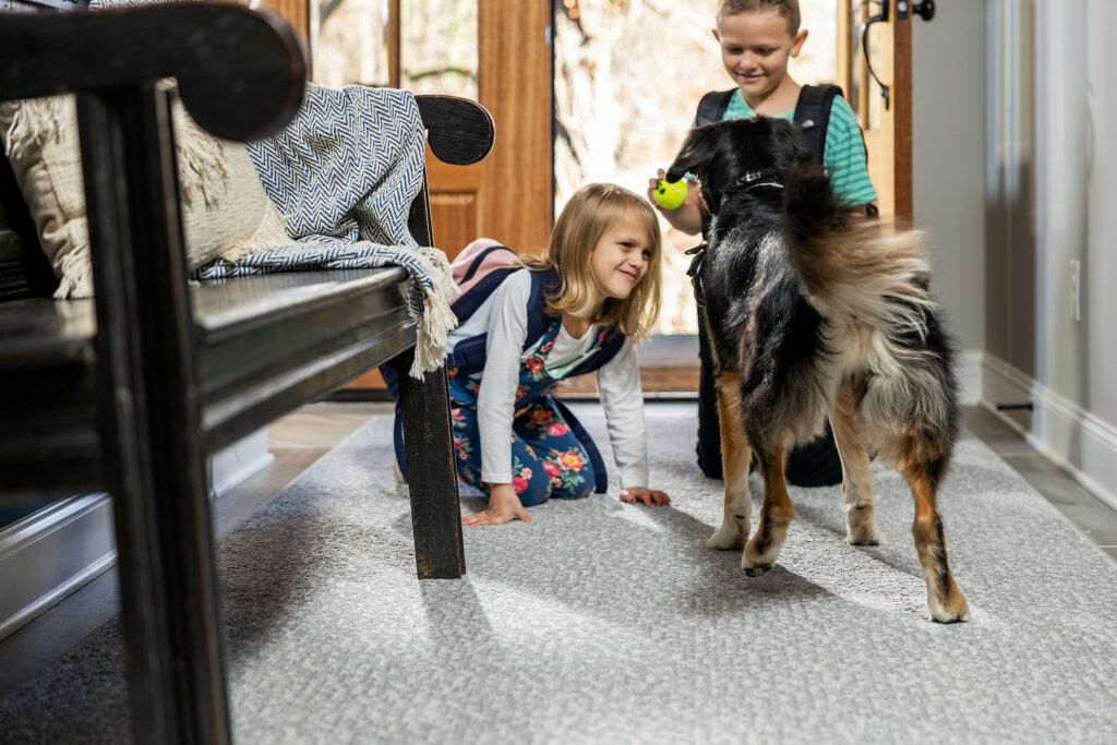 Kids plying with dog on carpet flooring | Wacky's Flooring